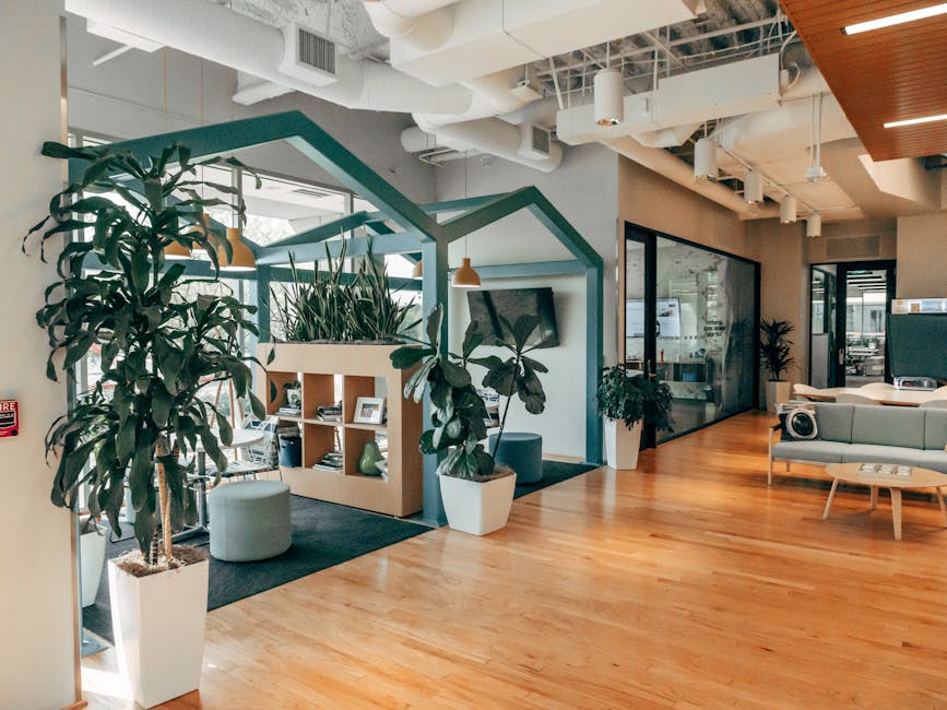 Stylish open office interior featuring natural light, modern design, and vibrant greenery for a refreshing atmosphere.