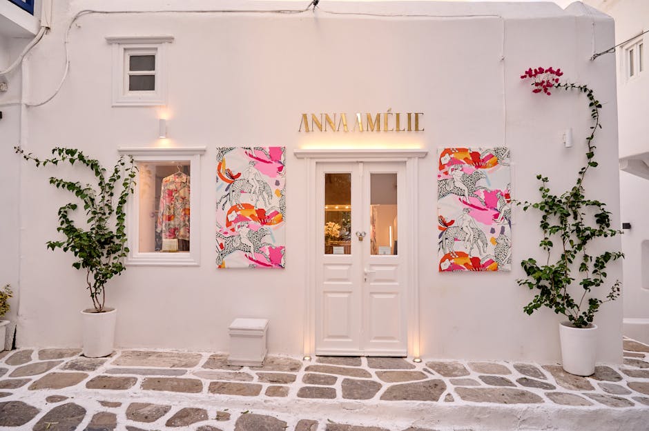 Cozy boutique facade adorned with vibrant artwork and lush greenery on stone path.